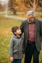Grandpa and his grandson are walking in the park. The spend time together Royalty Free Stock Photo