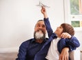 Grandpa, kid and playing with toy airplane in home, love and bonding together on vacation in living room. Happy family Royalty Free Stock Photo