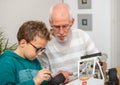 Grandpa and son little boy repairing model radio-controlled car at home