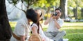 Grandpa takes pictures of granddaughter and grandma with his in park on sunny day happiness. concept grandparent and Royalty Free Stock Photo