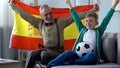 Grandpa waving Spanish flag, together with boy rejoices victory of football team Royalty Free Stock Photo
