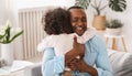 Grandparent grandchild relationship. Senior African American man hugging his granddaughter at home Royalty Free Stock Photo
