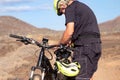 Grandparent 70 year old man doing sport with his electric bike. Yellow helmet Outdoor activity in arid path in the sunset light Royalty Free Stock Photo