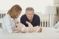 Grandparents and the baby are playing on the bed. Royalty Free Stock Photo