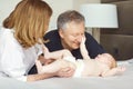 Grandparents and the baby are playing on the bed. Royalty Free Stock Photo