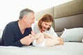 Grandparents and the baby are playing on the bed . Royalty Free Stock Photo