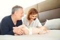 Grandparents and the baby are playing on the bed. Royalty Free Stock Photo