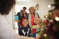 Grandparents Being Greeted By Family As They Arrive For Visit On Christmas Day With Gifts Royalty Free Stock Photo