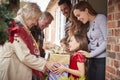 Grandparents Being Greeted By Family As They Arrive For Visit On Christmas Day With Gifts Royalty Free Stock Photo