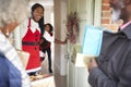 Grandparents Being Greeted By Mother And Children As They Arrive For Visit On Christmas Day With Gifts Royalty Free Stock Photo