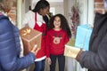 Grandparents Being Greeted By Mother And Daughter As They Arrive For Visit On Christmas Day With Gifts Royalty Free Stock Photo