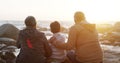 Grandparents, child and beach for sunset relax on rocks with back for connection, bonding or travel. People, kid and Royalty Free Stock Photo