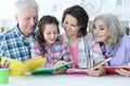Grandparents with cute little girl doing homework Royalty Free Stock Photo