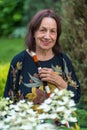 Portrait of happy older wrinkled smiling woman of eighty or ninety years old, staying in her garden.