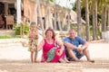 Grandparents enjoying day with granddaughter while blowing soap bubbles on the beach near the sea Royalty Free Stock Photo