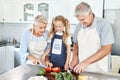 Grandparents, girl child in kitchen and cooking healthy food with vegetables on cutting board for happy family lunch at