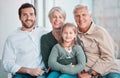 Grandparents, girl and father in portrait on sofa with hug, care or bonding with love in family home lounge. Elderly