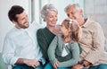 Grandparents, girl and happy with dad on sofa for hug, care or bonding with love in family home lounge. Elderly people