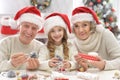 Grandparents with grandchild preparing for Christmas together Royalty Free Stock Photo