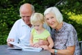 Grandparents with grandchild watching photo album Royalty Free Stock Photo