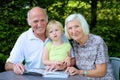 Grandparents with grandchild watching photo album Royalty Free Stock Photo