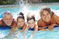 Grandparents With Grandchildren On Airbed In Swimming Pool