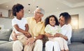 Grandparents, grandchildren and children with elderly people in a home bonding, playing and enjoying quality time