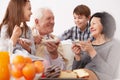 Grandparents and grandchildren eating a cake