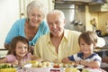 Grandparents And Grandchildren Eating Meal Together In Kitchen Royalty Free Stock Photo