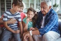 Grandparents and grandchildren looking at smartwatch in living room Royalty Free Stock Photo