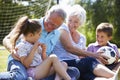 Grandparents And Grandchildren Playing Football In Garden