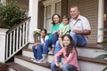 Grandparents With Grandchildren Sit On Steps Leading Up To Home Royalty Free Stock Photo