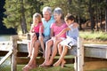 Grandparents with grandchildren sitting by a lake