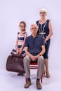 Grandparents and granddaughter on a gray background in full length