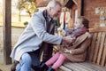Grandparents With Granddaughter Outside House Getting Ready To Go For Winter Walk Royalty Free Stock Photo