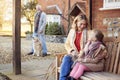 Grandparents With Granddaughter Outside House Getting Ready To Go For Winter Walk Royalty Free Stock Photo