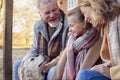 Grandparents With Granddaughter And Pet Dog Outside House Getting Ready To Go For Winter Walk Royalty Free Stock Photo