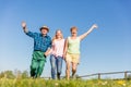 Grandparents with granddaughter running happy on the field