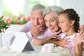 Grandparents with granddaughter using tablet at home Royalty Free Stock Photo