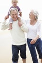 Grandparents And Granddaughter Walking Along Beach Together Royalty Free Stock Photo