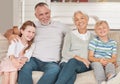 Grandparents, grandkids and being happy to relax and smile together on sofa in living room. Portrait, grandfather and
