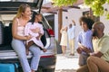 Grandparents Greeting Grandchildren As Family Unpack Car On Family Holiday