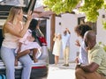 Grandparents Greeting Grandchildren As Family Unpack Car On Family Holiday