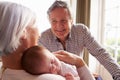 Grandparents Holding Sleeping Newborn Baby Granddaughter