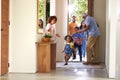Grandparents At Home Opening Door To Visiting Family With Children Running Ahead Royalty Free Stock Photo