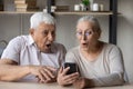 Grandparents open mouth gawp at cellphone screen, read unbelievable news Royalty Free Stock Photo