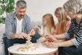 Grandparents play tower game with two girls