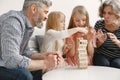 Grandparents play tower game with two girls