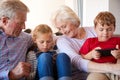 Grandparents Playing Video Games With Grandchildren On Mobile Phones At Home Royalty Free Stock Photo