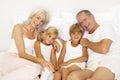 Grandparents Relaxing On Bed With Grandchildren Royalty Free Stock Photo